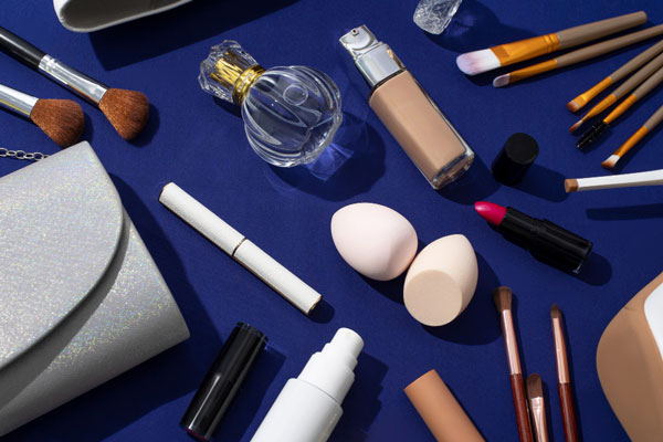 Various cosmetics and makeup products on a blue surface.