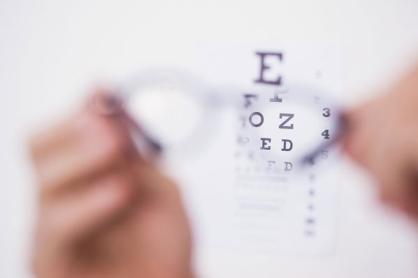 A person holding an eye chart with an eye chart, used for testing visual acuity.